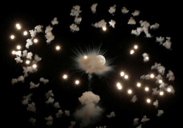 Fireworks explode in front of the full moon during celebrations marking the feast of the