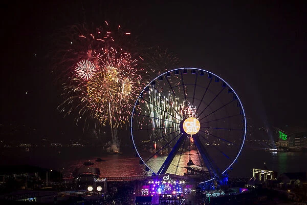 Fireworks explode near the observation wheel during a pyrotechnic show to celebrate