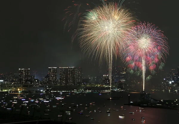 Fireworks explode over small ships on the Tokyos Odaiba bay during the Tokyo bay