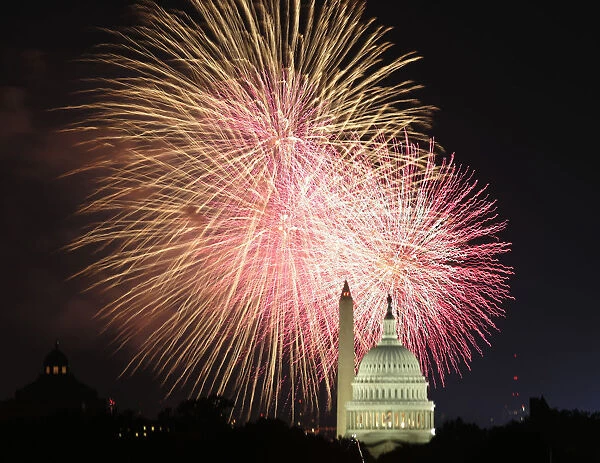 Fireworks explode over the United States Capitol dome and Washington Monument on Independence