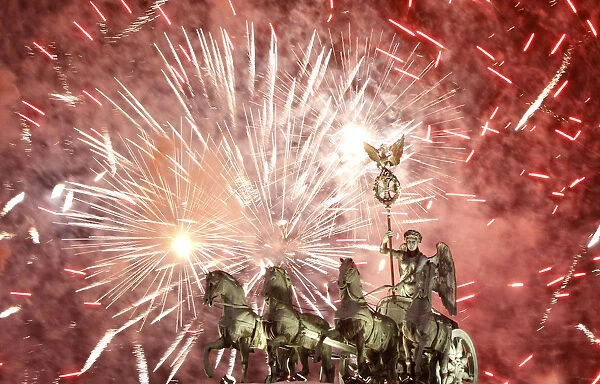 Fireworks illuminate Quadriga sculpture atop Brandenburg Gate in Berlin
