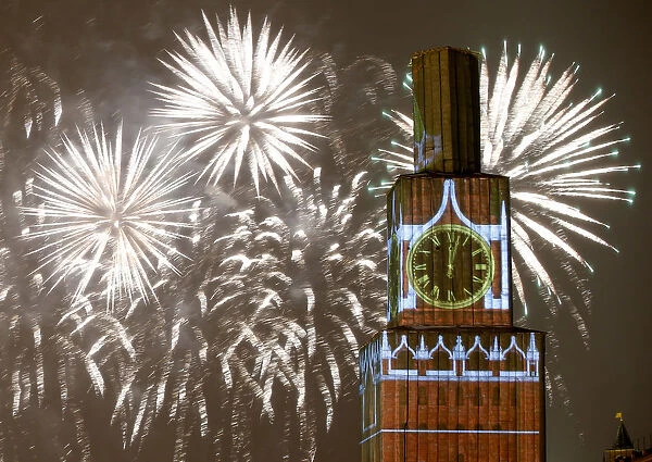 Fireworks light the sky over the Kremlins Spasskaya Tower, covered by scaffolding