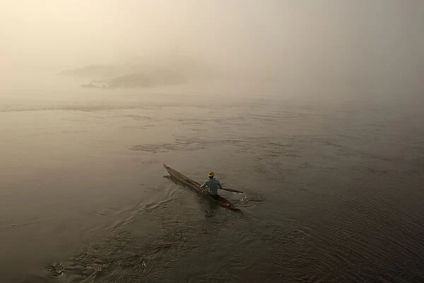 A fisherman paddles his boat on the river Oubangui in Bangui