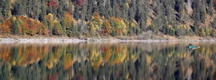 Framed Print : A fisherman rows his boat during a sunny autumn day at the Sylvenstein barrier lake Framed Print : A fisherman rows his boat during a sunny autumn day at the Sylvenstein barrier lake