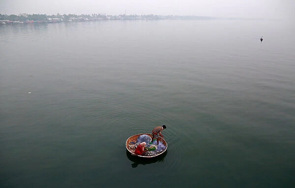 A fisherman and his wife catch fish in the waters of Vembanad Lake in Kochi