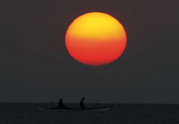 Fishermen travel in a motorboat through a river as the sun sets at Marinduque island