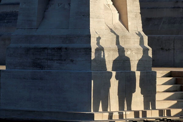 Flag-bearers of war veteran associations cast their shadows during a ceremony at the