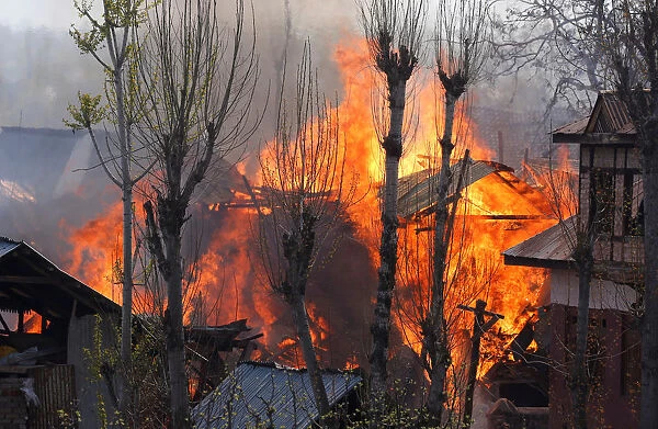 Flames and smoke billow from residential houses after they caught fire during a gunbattle