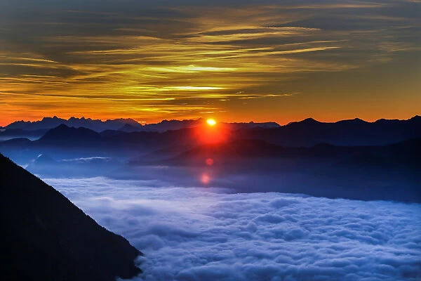 Fog covers the Inntal valley as the sunrise is seen from the Hundskopf mountain in