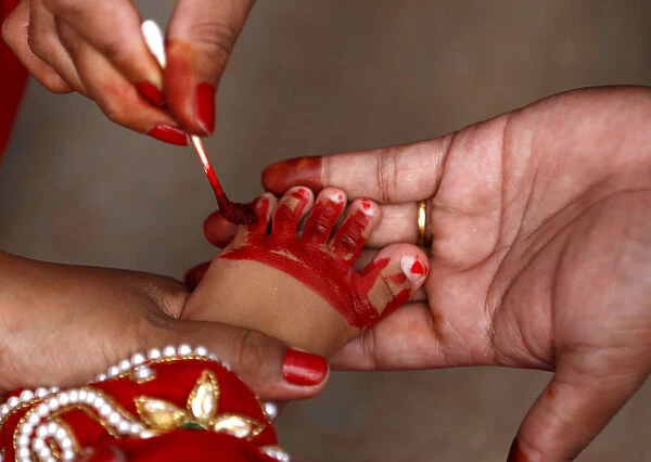 The foot of a young girl dressed as the Living Goddess Kumari is painted red as part of