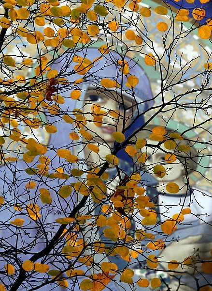 Fresco is seen through autumn leaves in a park in St. Petersburg
