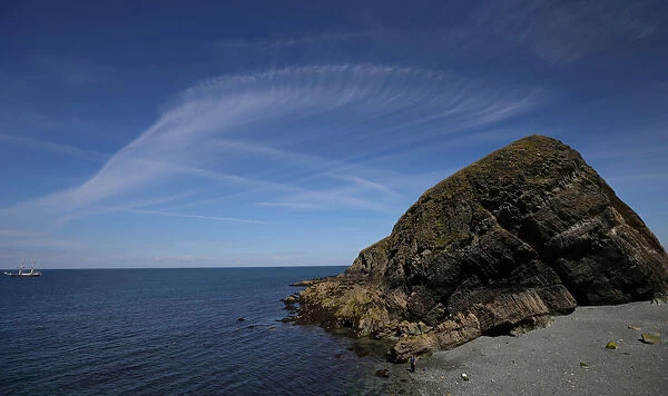 General view showing Cirrus clouds over a rock on rat Island during the Cloud