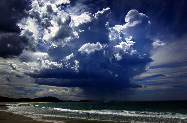 A giant storm cloud can be seen in the sky above swimmers near Mollymook Beach, south