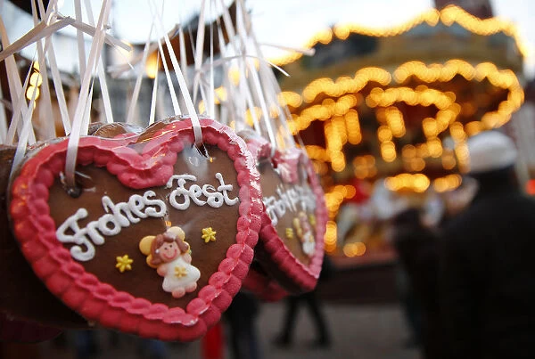Gingerbread hearts reading Merry Christmas are on display at a booth at the opening