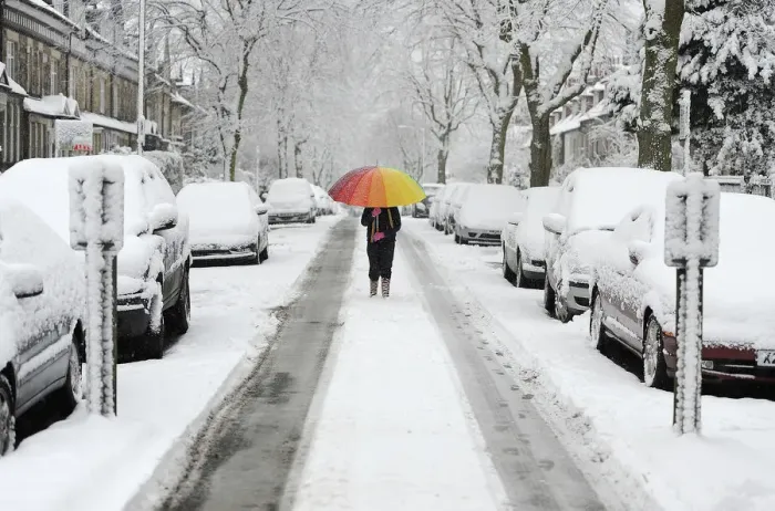 Framed Print : A girl walks along a snow covered street in Knaresborough