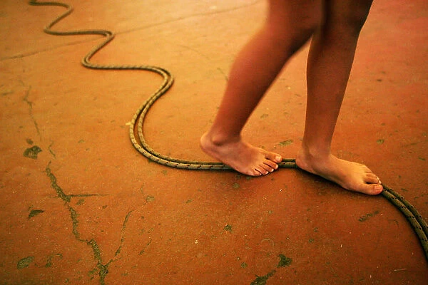 A girls walks on a rope on the floor during a circus workshop in a Caracas neighborhood