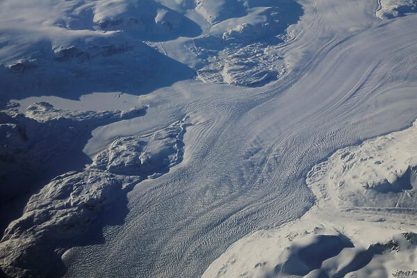 A glacier is seen making a path through mountains on the eastern coast of Greenland