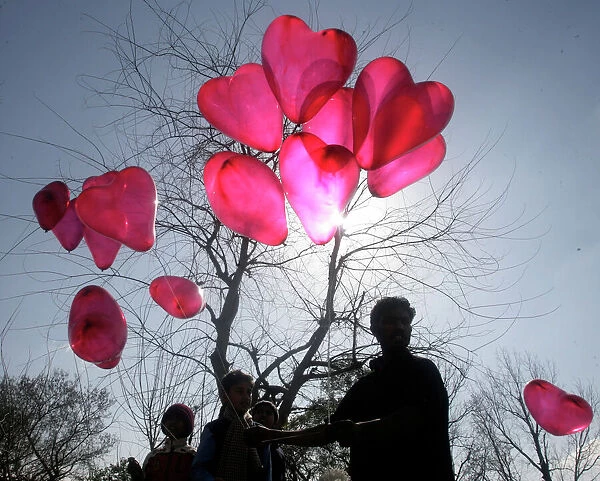 GM1E52E1MM701. A man sells heart shaped balloons on Valentine's Day in