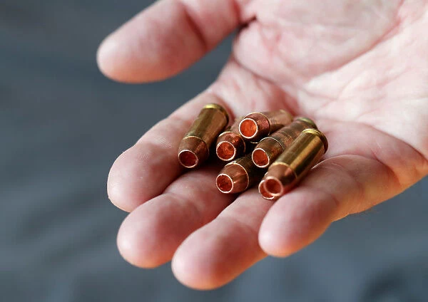 A gun owner displays 10 mm Auto cartridges with Barnes TAC-XP hollow point bullets in
