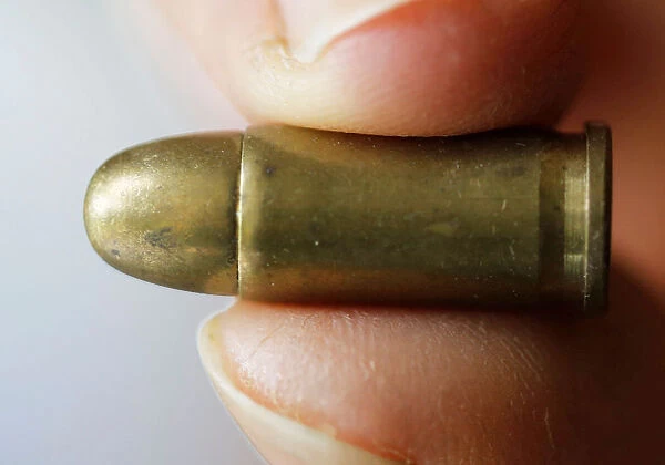 A guns collector holds a 7. 65 caliber bullet in his house in Bordeaux