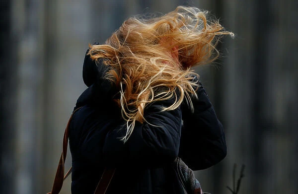 The hair of a woman is whirled during heavy storms in Cologne