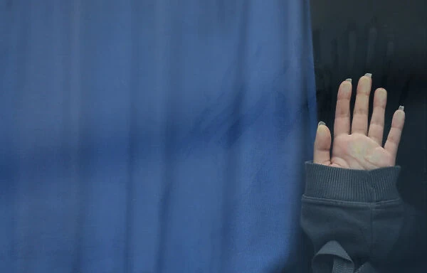 A hand of a migrant touches a bus window at the Croatia-Slovenia border crossing at