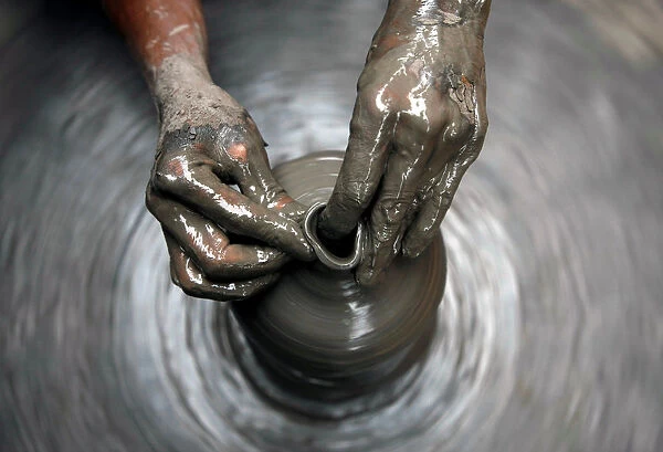 Hands of a man are pictured as he makes earthenware in Bhaktapur