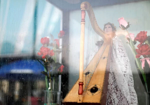 A harp that is held by an image of Saint Cecilia, patron of musicians