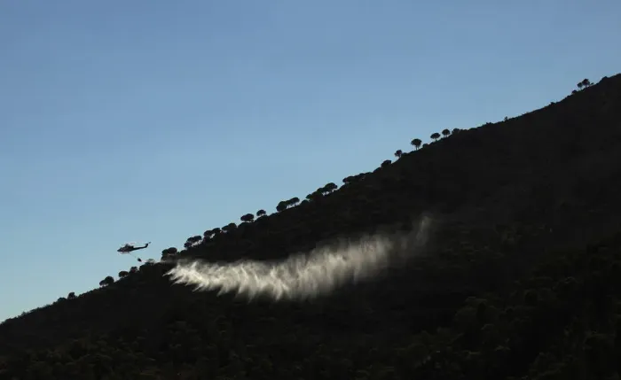 Framed Print : A helicopter drops water over a wildfire in the neighborhood of Entrerrios in Mijas