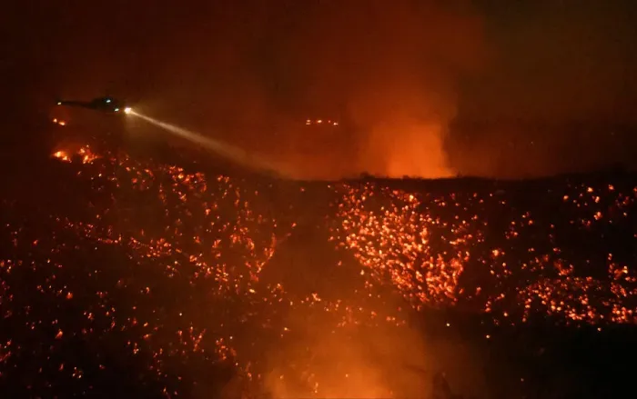 Framed Print : A helicopter flies above glowing embers as it makes a water drop run at the Old Fire