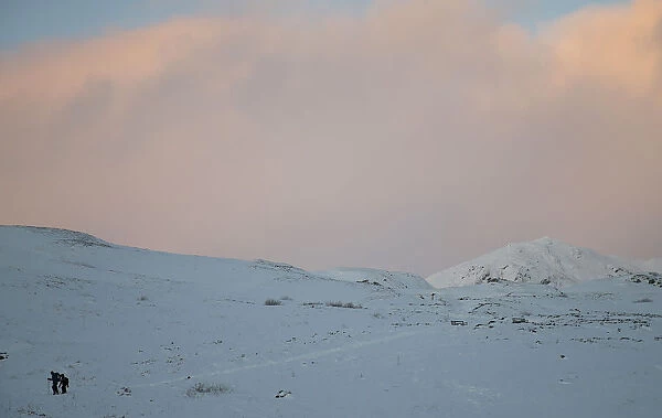 Hillwalkers descend Ben Vrackie during wintry weather near Pitlochry, Scotland