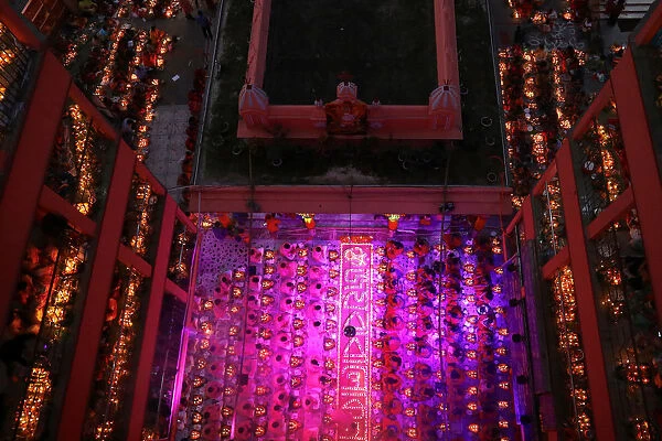 Hindu devotees sit together on the floor of a temple to observe Rakher Upabash, in Dhaka