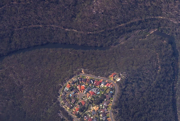 Homes can be seen near a river and bordering bushland in south-western Sydney