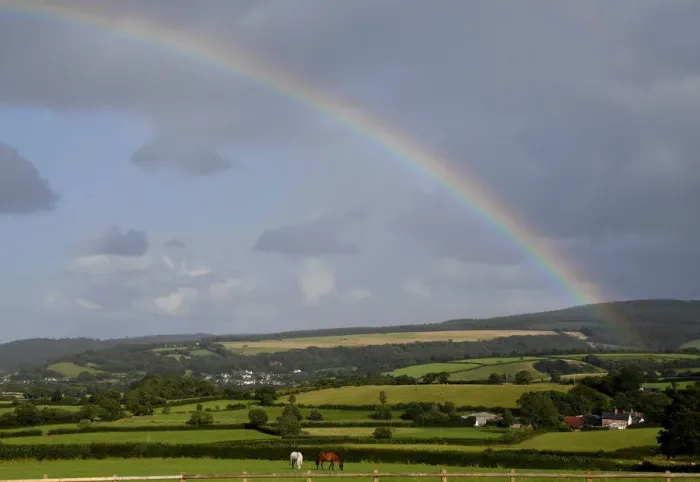 Framed Print : Horses graze in a field as a rainbow forms behind in Exmoor National Park, near Minehead Framed Print : Horses graze in a field as a rainbow forms behind in Exmoor National Park, near Minehead