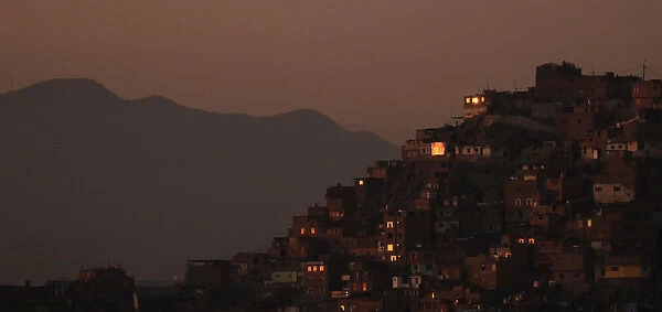 Houses on a hill are pictured at sunset in Lima