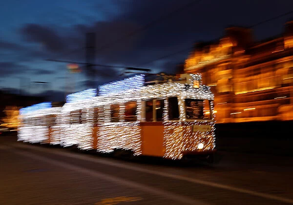 Hungarians travel by tram decorated with Christmas lights in the centre of Budapest