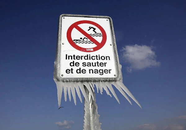 Ice is pictured on a a warning sign at the harbour of Versoix near Geneva