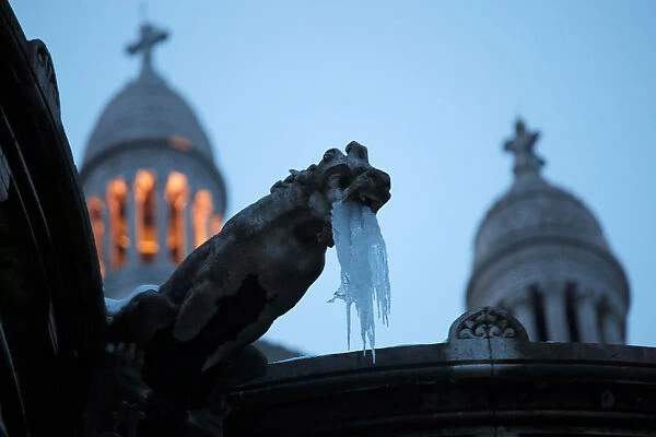 Icicles hang from a gargoyle on the Sacre Coeur basilica at the Butte Montmartre in Paris
