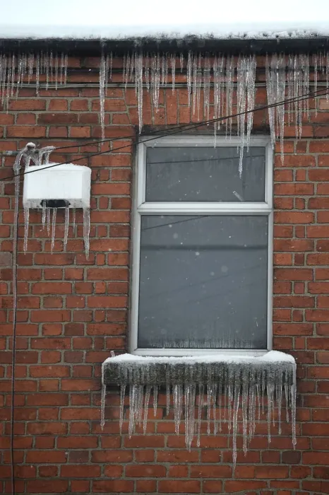 Framed Print : Icicles are seen hanging from a window and house alarm during snow fall in Dublin Framed Print : Icicles are seen hanging from a window and house alarm during snow fall in Dublin