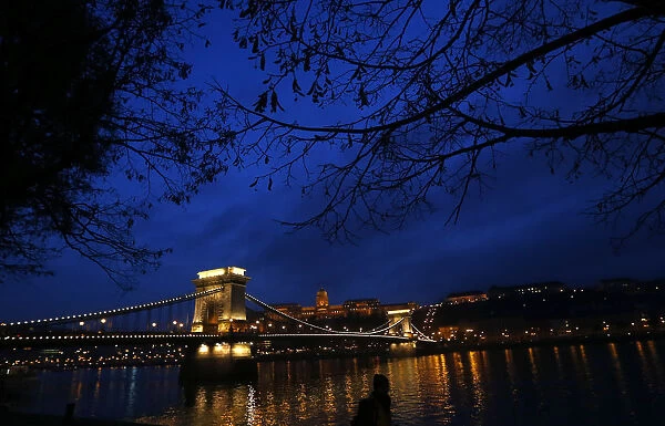 The iconic Chain Bridge of Budapest spans the Danube river and the Royal Palace is
