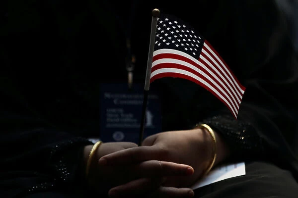 An immigrant woman holds a U. S. flag during a U. S. Citizenship