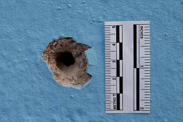 The impact from a bullet is seen on a wall on the rue du Savon after the deadly shooting