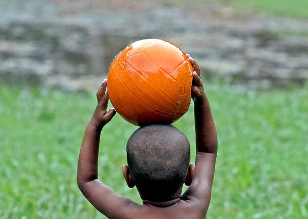 An Indian child plays with a basketball in a field in the eastern Indian city of Calcutta