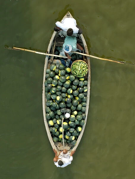 Indian farmers carry watermelons on a boat across the river Ganges in Allahabad