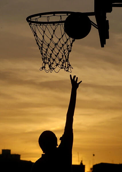 An Indian girl plays basketball in the evening in Chennai