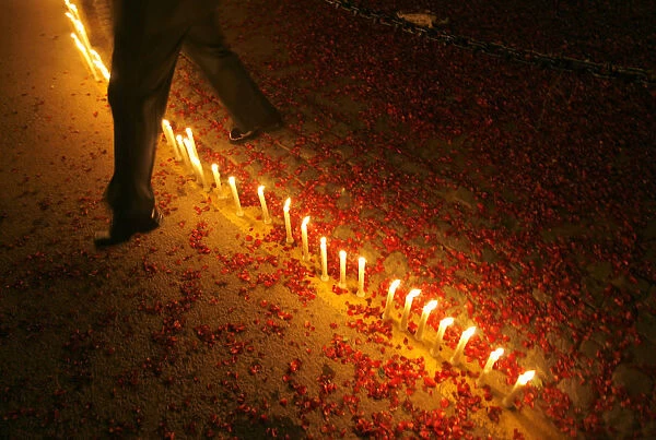 Indian soldier crosses over candles lit by school children during Vijay Divas in New