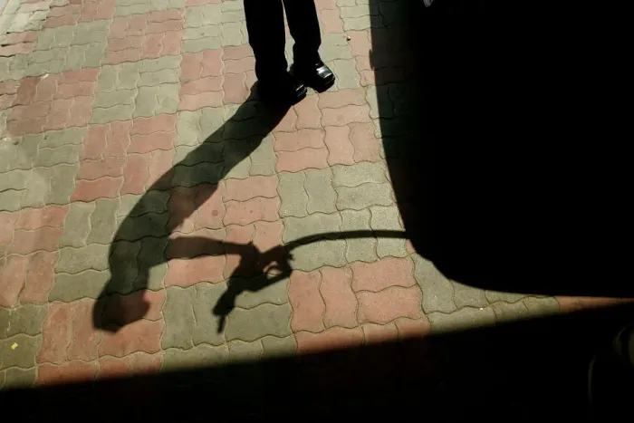 Framed Print : An Indian worker lifts a petrol nozzle at a petrol pump in New Delhi
