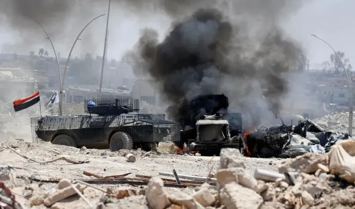 Framed Print : An Iraqi military armoured fighting vehicle (AFV) drives past a burning Iraqi military