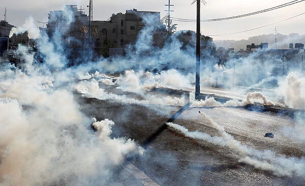Israeli forces fire gas canisters at Palestinian protesters during a protest in the West