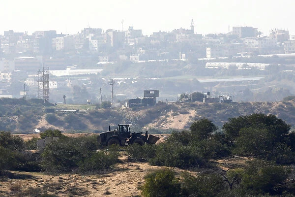 An Israeli military bulldozer is seen on the Israeli side of the border with the northern